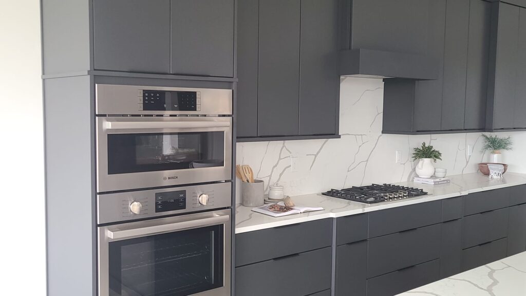 Refinished dark gray shaker kitchen cabinets with marble backsplash in a Meridian home