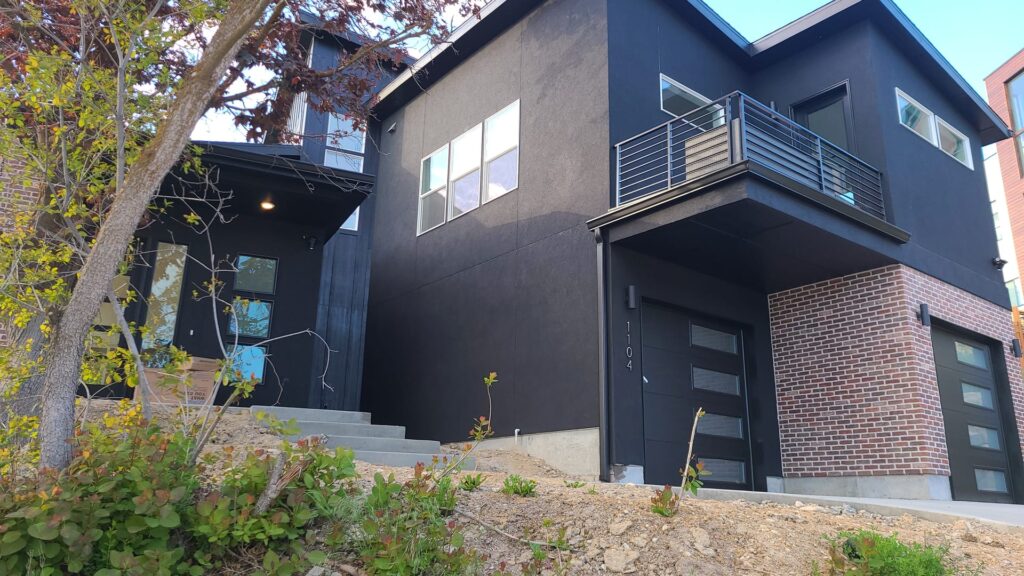 Modern dark stucco and brick new construction exterior in Boise Idaho at dusk
