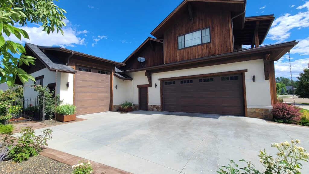 Freshly painted modern craftsman exterior with vertical wood siding and stone accents in Eagle Idaho