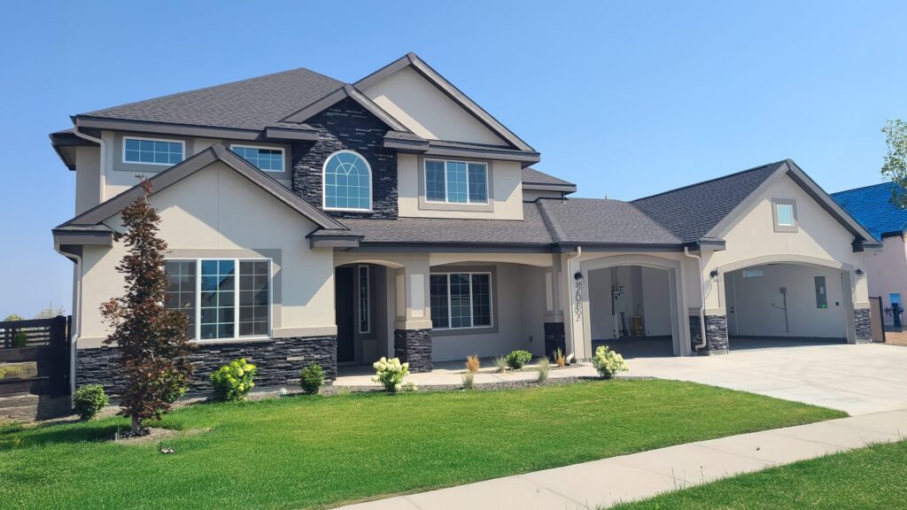 Freshly painted two story craftsman exterior in Meridian Idaho with warm cream stucco and charcoal trim