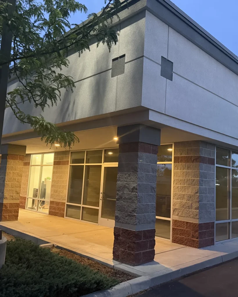 Modern multi-tenant commercial retail building at dusk, exterior painted by All Shades of Painting in Meridian
